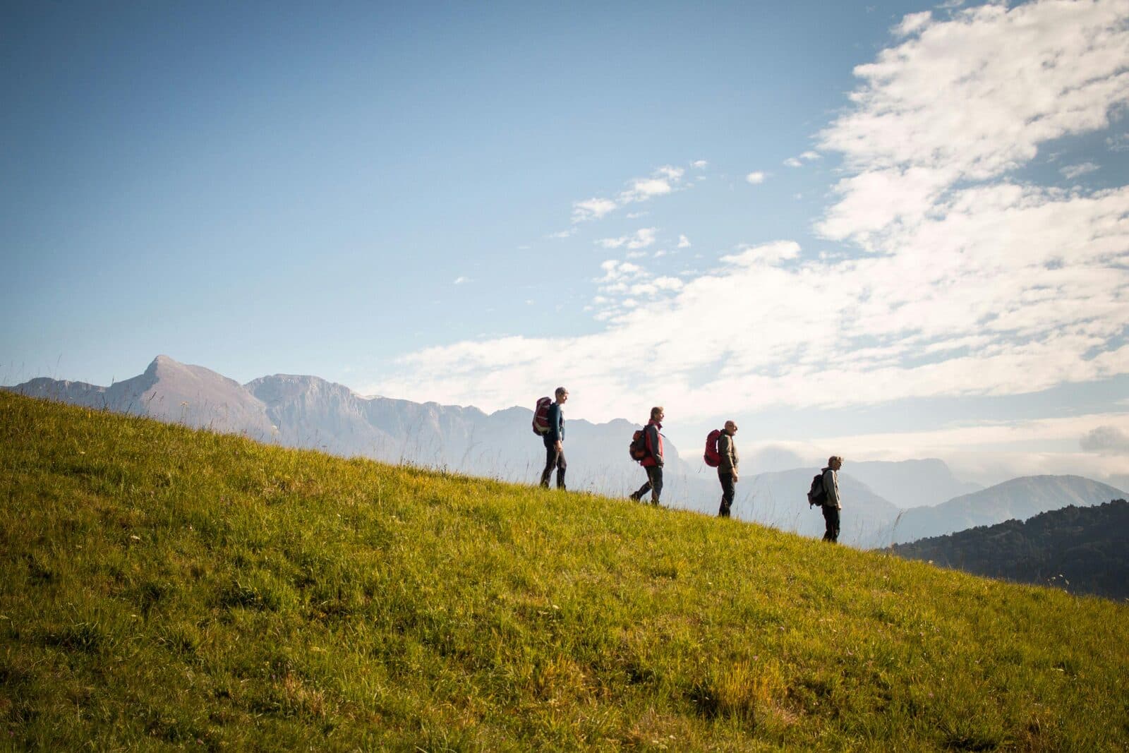 Personnes randonnant sur un sentier de montagne, paysage panoramique en arrière-plan