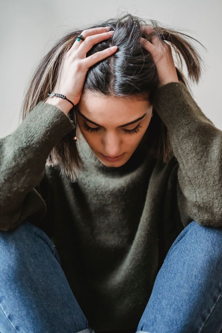 Une personne âgée assise confortablement dans un fauteuil, les yeux fermés, pratiquant une technique de respiration pour apaiser son anxiété post-opératoire.